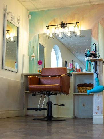Cozy salon chair with warm lighting and styling tools.