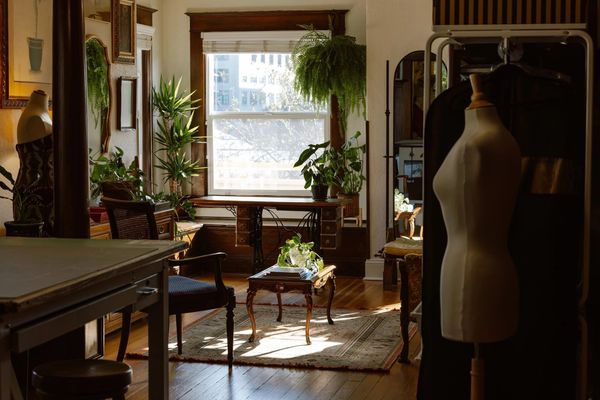 Sunlit cozy room with vintage furniture and sewing mannequins.