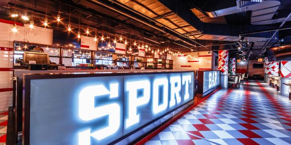 Modern sport bar interior with bright lighting and tiled floor.