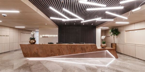 Modern reception desk with geometric design and LED lighting.