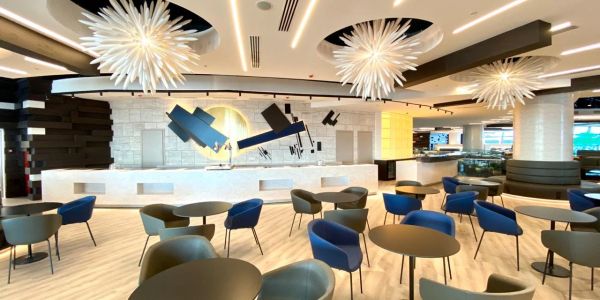 Modern cafe seating area with artistic wall and pendant lights.