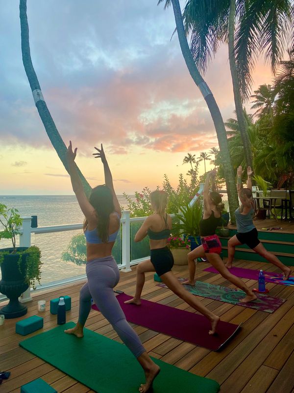 Crescent lunge yoga pose on an oceanfront patio in Honolulu, Hawaii near Diamondhead and Hawaii Kai