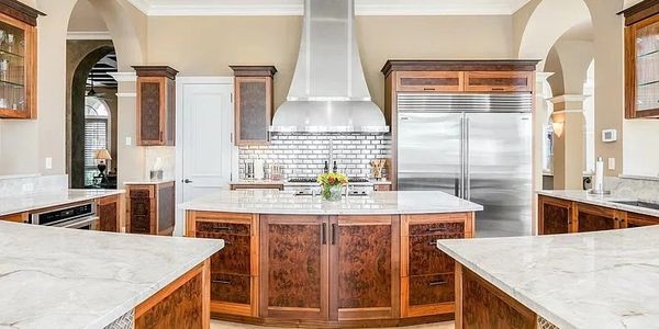 Spacious kitchen with wooden cabinets and marble countertops.