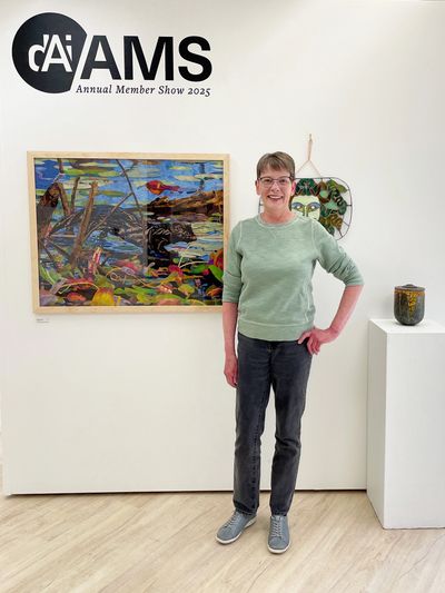 Woman posing in front of colorful artwork at the Duluth Art Institute 2025 Annual Member Show.