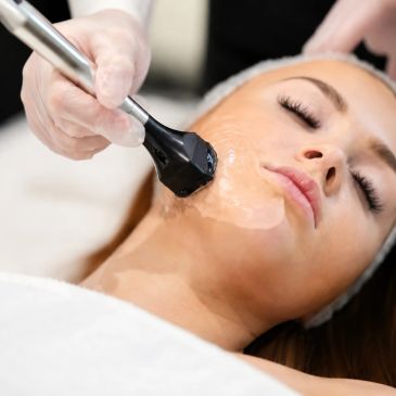 Woman receiving facial treatment with a device.