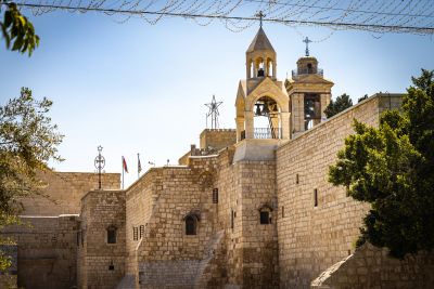 Ancient stone church with bell towers under a blue sky.