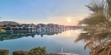 Peaceful waterfront view with houses and a boat at sunset.