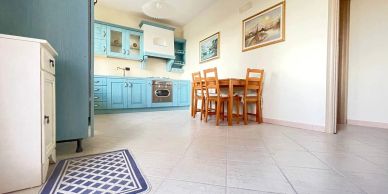 Bright kitchen with blue cabinets and wooden dining set.