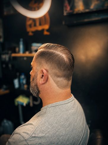 Man met een nette, korte haarstijl gezien vanaf de achterkant.