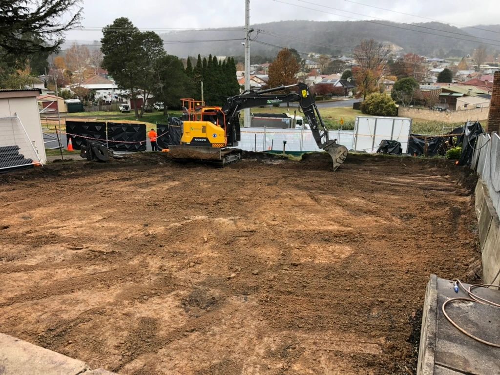 an excavator parked at the front of a clean job site