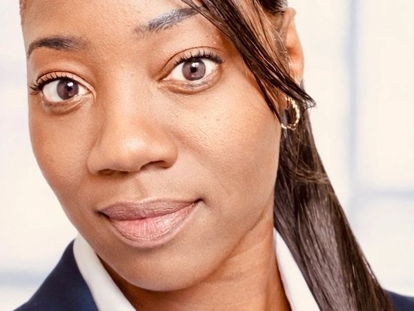 Close-up portrait of a confident woman with hoop earrings and sleek hair.