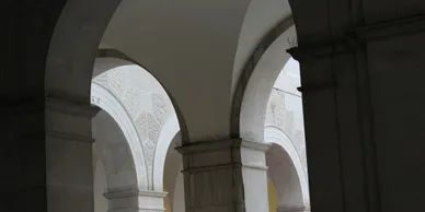 Grayscale image of multiple stately arches found in a building of authority such as a courthouse