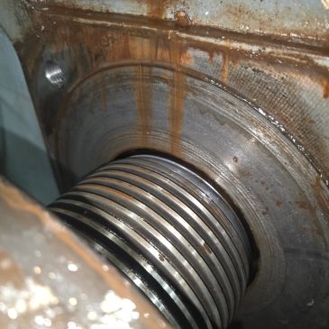Close-up of rusted mechanical spring and metal surface.