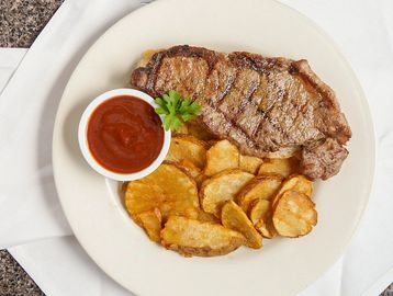 Grilled steak with potato wedges and ketchup Bristol Bar & Grille Louisville