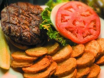 Grilled Bristol burger with lettuce, tomato, and potato wedges.