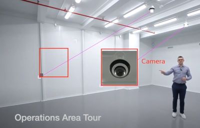 A man explains the security system in a cannabis facility by pointing to a dome camera installed in 