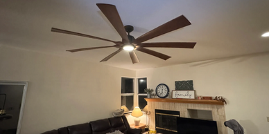 Spacious living room with a large ceiling fan and cozy seating area.