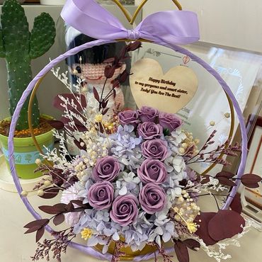 Elegant floral basket with purple roses and a birthday message for a sister.