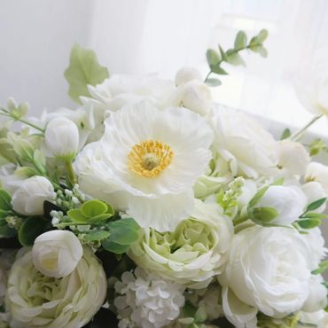 Elegant white and green floral arrangement with soft petals and greenery.