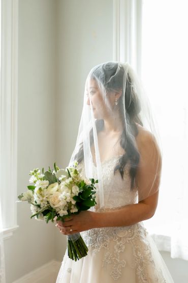 Bride in wedding dress holding a bouquet.