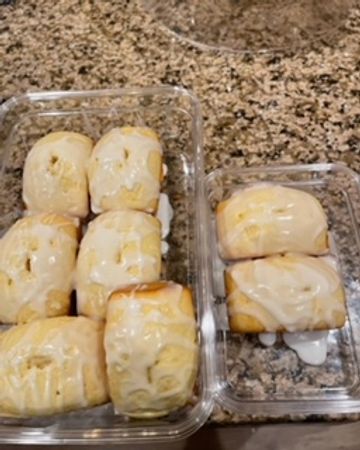 Two containers of glazed pastries on a kitchen countertop.