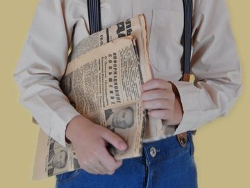 Newsie boy holding a newspaper