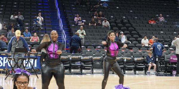 Cheerleaders performing at a basketball court.