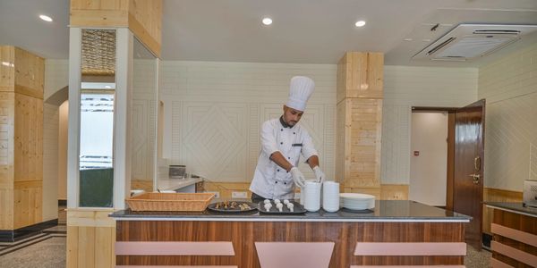 A chef in a modern kitchen preparing plates with food.
