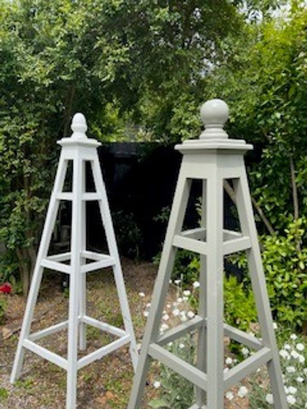 Two different types of garden obelisks in a garden