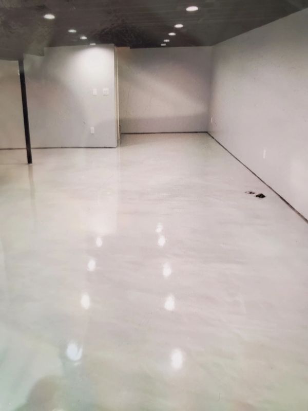 Empty room with polished concrete floor and recessed ceiling lights.