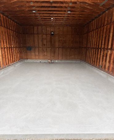 Empty wooden garage with concrete floor.
