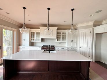 Modern kitchen with white cabinets and a large dark island.