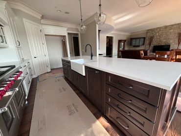 Modern kitchen with a large island and farmhouse sink under pendant lights.