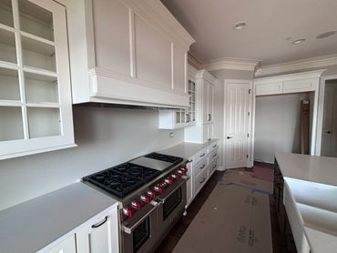 Modern kitchen with white cabinetry and stainless steel stove.