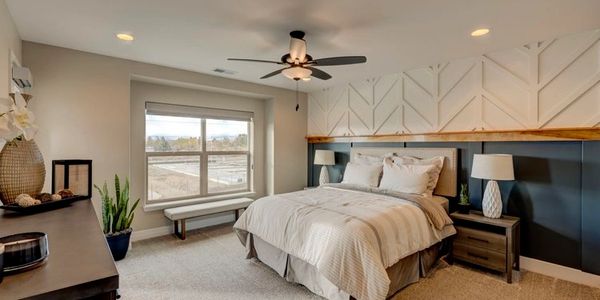 Modern bedroom with neutral tones and a patterned accent wall behind the bed.