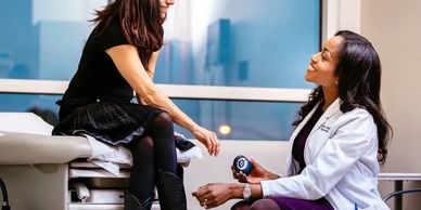 Doctor consulting a female patient in a clinic room.