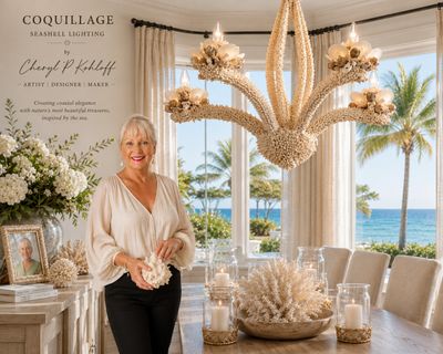 Elegant woman holding seashell art in a bright, coastal-inspired room with chandelier.
