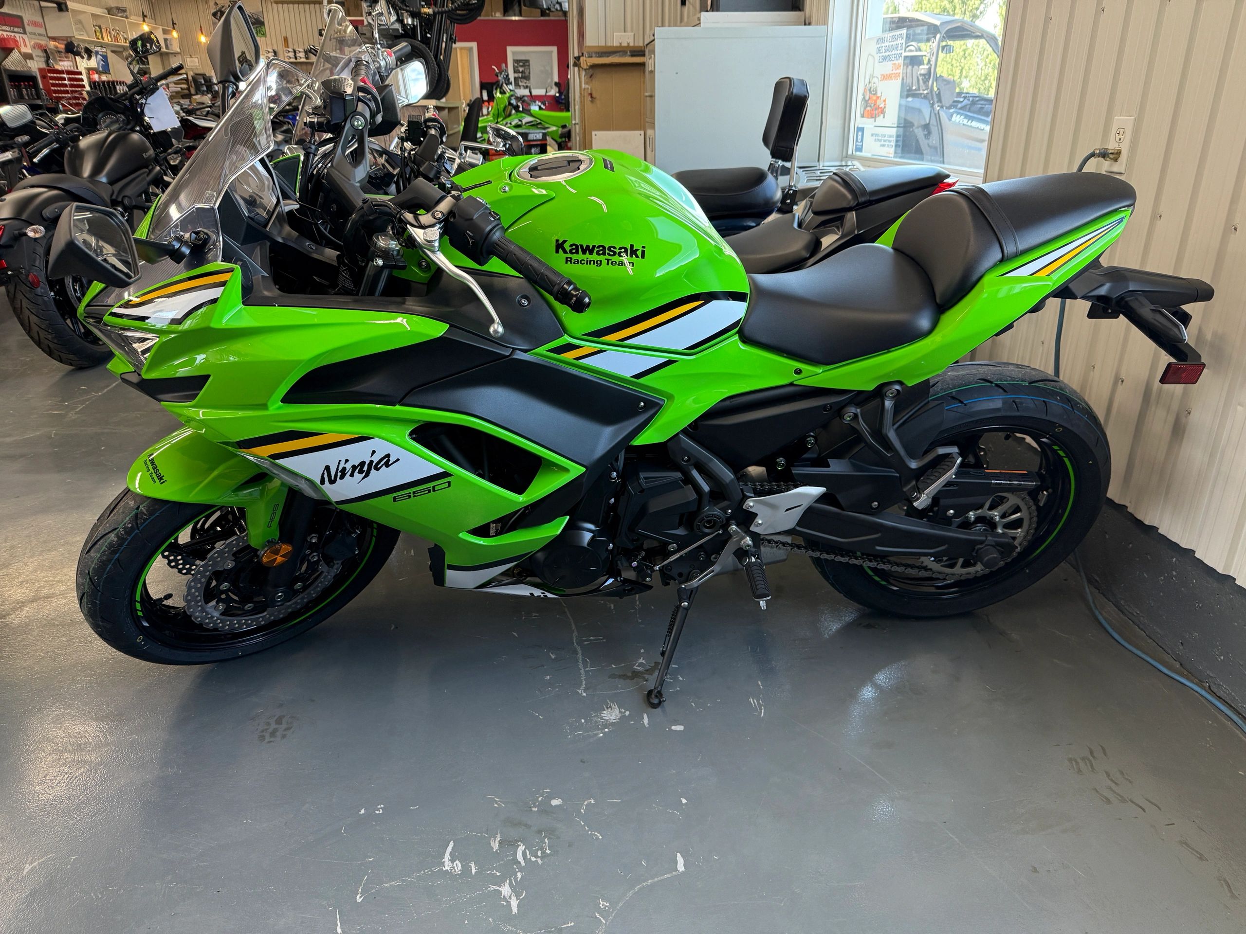 Bright green Kawasaki Ninja 650 motorcycle in a showroom.