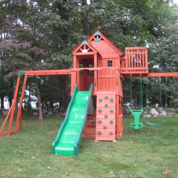 A picture of swing set and slider in green color