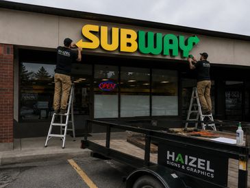 Our team installing the subway exterior sign in ottawa storefront.