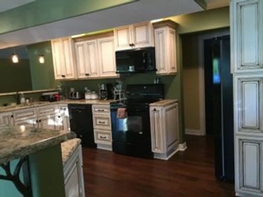 A green kitchen with cabinetry and appliances