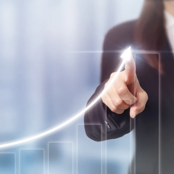 Businesswoman pointing at an upward growth graph with glowing arrow.