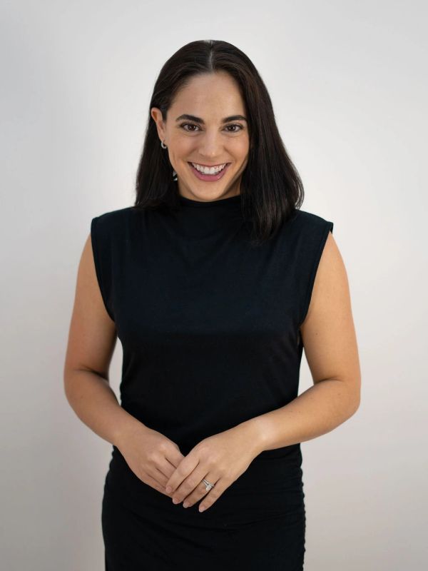 Smiling woman in a black sleeveless top.