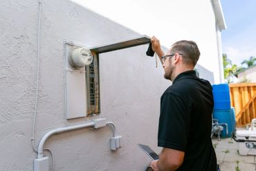 A person checking the meter on the wall 