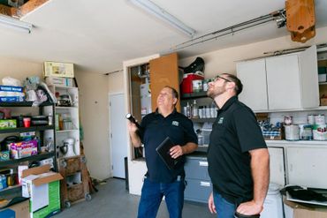 Two persons inspecting the ceiling of house