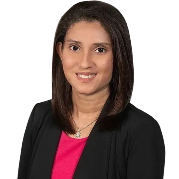Professional woman with shoulder-length hair, wearing a black blazer and pink top, smiling at the camera.
