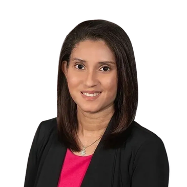Professional woman smiling, wearing a black blazer and pink top.