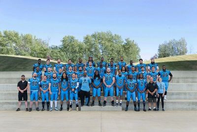 players and coaches taking team photo at Mac Island SMS stadium . Blue jerseys