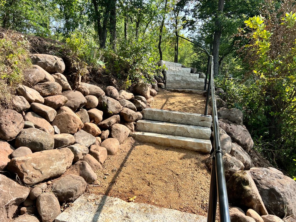 Steps to the lake, black hand railing and gravel walk way