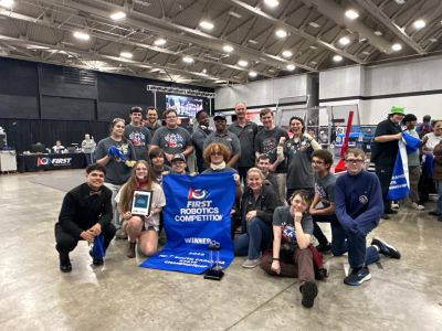Group of students celebrating robotics competition win.